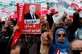 People carry banners and flags during a rally in support of Tunisian President Kais Saied in Tunis, Tunisia May 8, 2022.