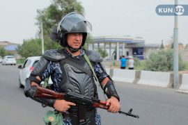 An Uzbek law enforcement officer guards a street in Nukus