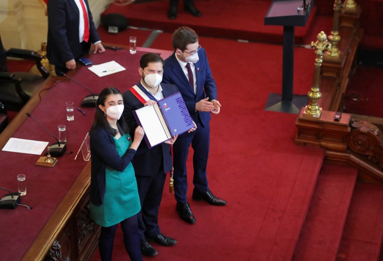 Leaders of Chile's Constituent Assembly hand over the draft of a new constitution to President Borich