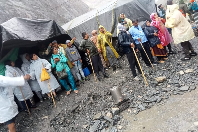 People stand outside tents after a cloudburst near the holy Amarnath cave shrine