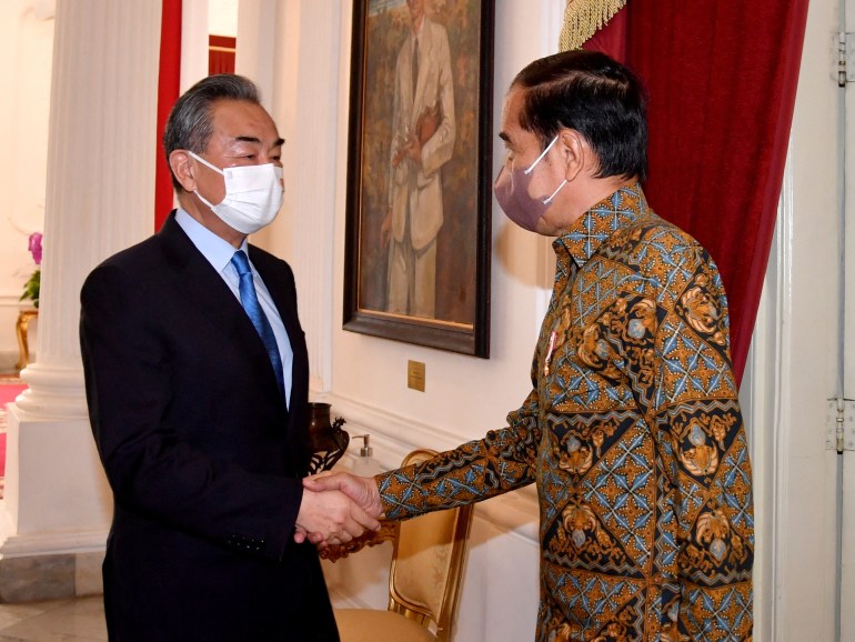 Indonesian President Joko Widodo shakes hands with Chinese Foreign Minister Wang Yi during a meeting at the Presidential Palace in Jakarta, Indonesia, July 11, 2022.