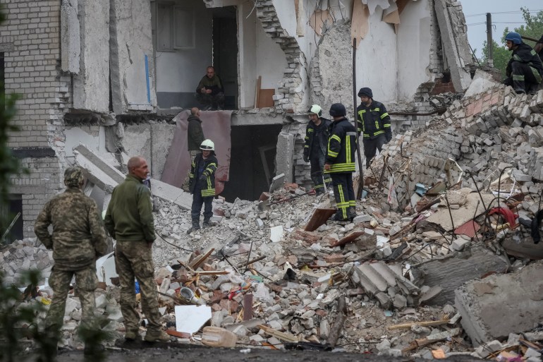 Rescuers work at a residential building damaged by a Russian military strike in the town of Chasiv Yar