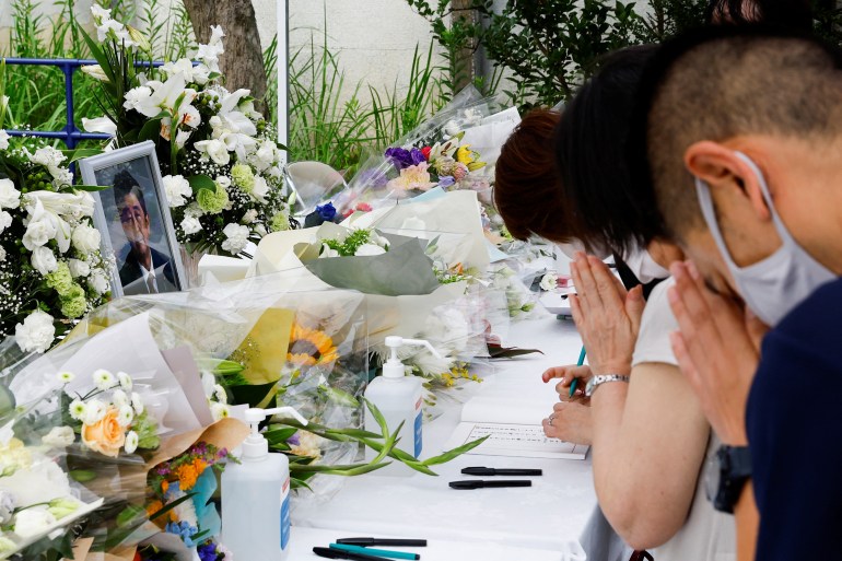 Mourners pray and leave white flowers for former Japanese Prime Minister Shinzo Abe