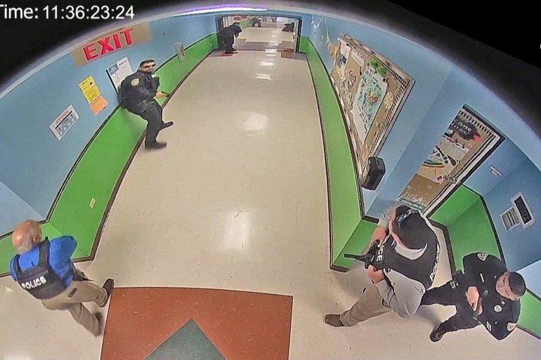 Police arrive to search hallways after Salvador Ramos entered Robb Elementary school to kill 19 children and two teachers in Uvalde, Texas, U.S. May 24, 2022 in a still image from school surveillance video obtained by the Austin American-Statesman newspaper. Austin American-Statesman/Handout via REUTERS. NO RESALES. NO ARCHIVES. MANDATORY CREDIT