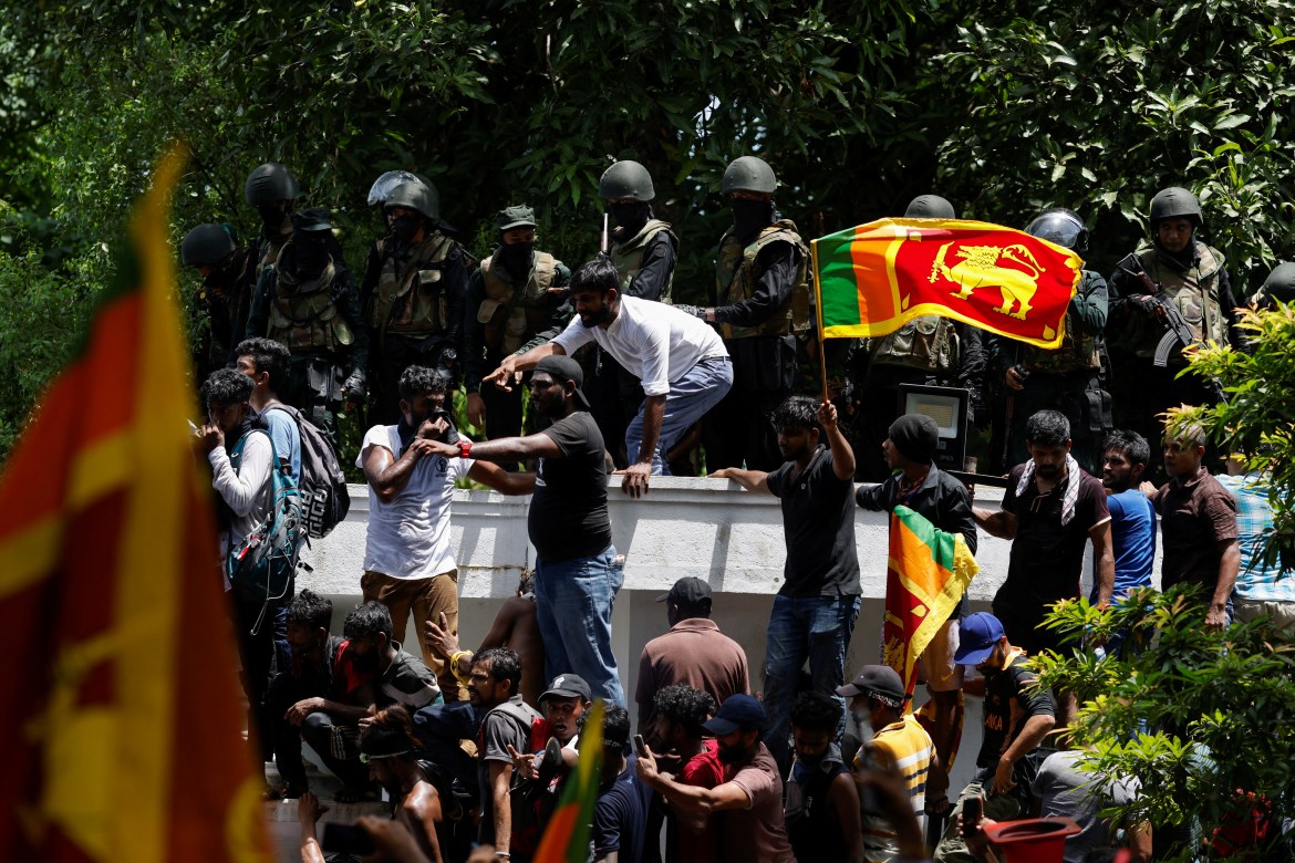 Demonstrators stand on the wall of Sri Lanka's Prime Minister Ranil Wickremesinghe's office