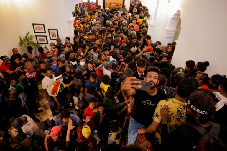 Demonstrators wait to enter into Sri Lankan Prime Minister Ranil Wickremasinghe's office during a protest demanding for his resignation, after President Gotabaya Rajapaksa fled, amid the country's economic crisis, in Colombo