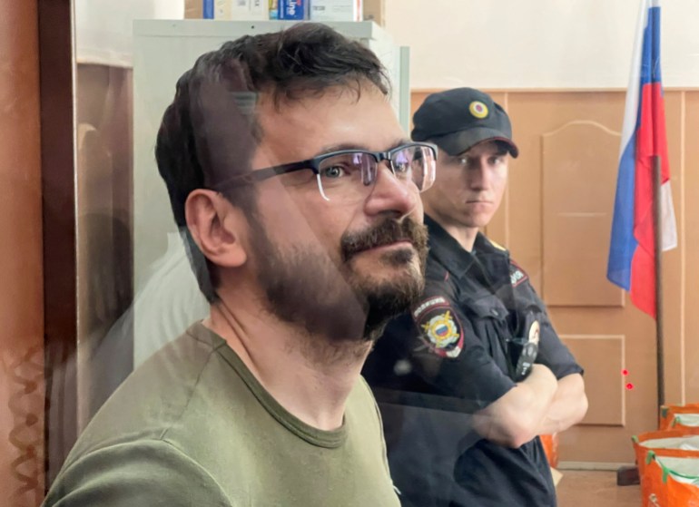 Russian opposition politician Ilya Yashin, detained on suspicion of spreading false information about Russia's army, stands inside a defendants' cage during a court hearing in Moscow, Russia July 13, 2022. 