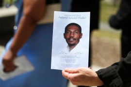 A man holds a programme following funeral services for Jayland Walker