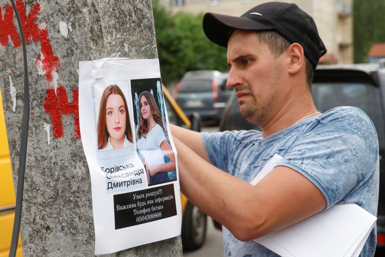 A man places a missing person poster at the site of a Russian missile strike in Vinnytsia, Ukraine on July 15, 2022 [Valentyn Ogirenko/Reuters]