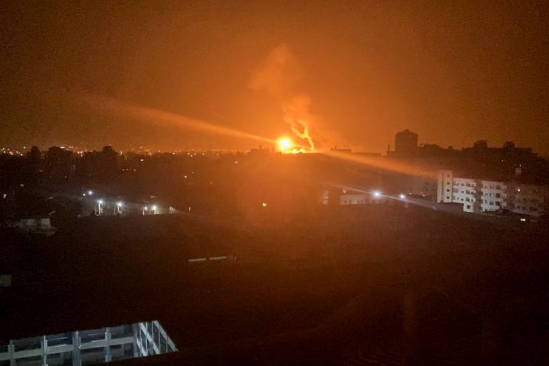 An explosion from an Israeli air raid on Gaza illuminates some buildings at night
