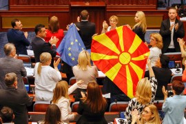North Macedonian members of Parliament from the ruling SDSM party, hold European Union and North Macedonian flags, during a parliamentary debate on a French-brokered deal aimed at settling disputes with Bulgaria and clearing the way to EU membership, in Skopje, North Macedonia,