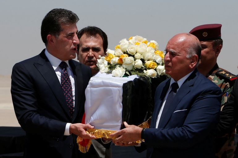 President of the Kurdistan region in Iraq Nechirvan Barzani carries the coffin of an Iraqi who was killed in an attack on a mountain resort in Iraq's northern province Dohuk, during funeral ceremony, at Erbil International Airport