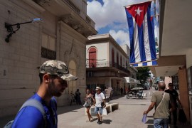 Cuban flags are displayed at a commercial road in downtown Havana