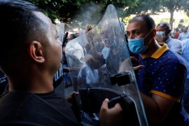 Protesters and police confront each other at a rally in Tunis