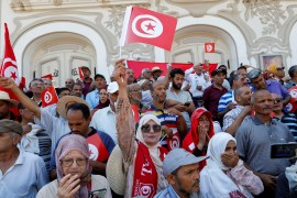 protesters wave Tunisian flags
