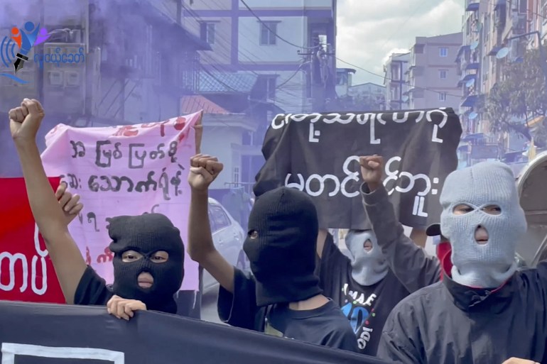 Prosters in black balaclavas march on the street in Yangon following the execution of four pro-democracy activists and politicians