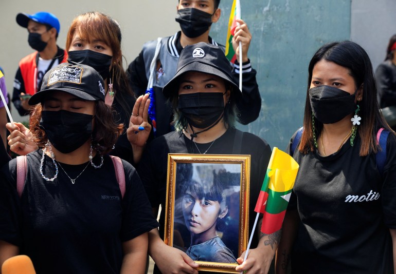 A Myanmar protester carrying a photo of Aung San Suu Kyi at a rally in Thailand