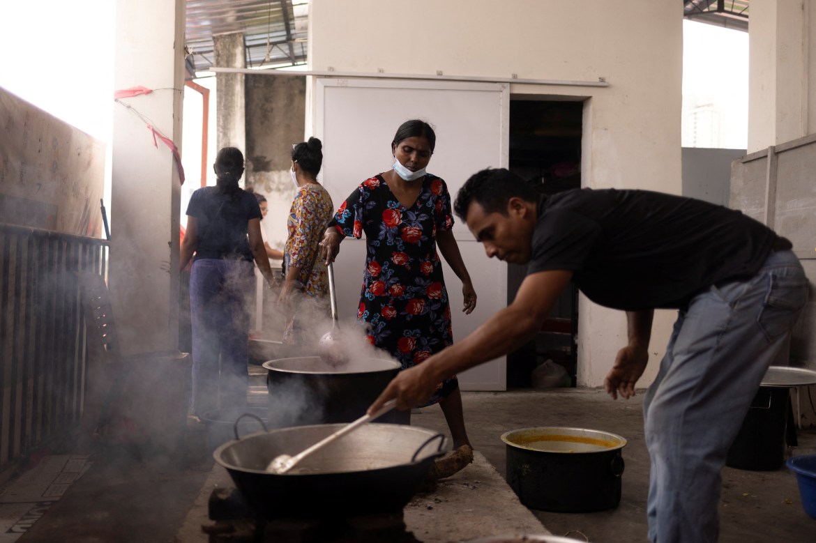 Moses Akash De Silva prepares food inside a community kitchen at a church
