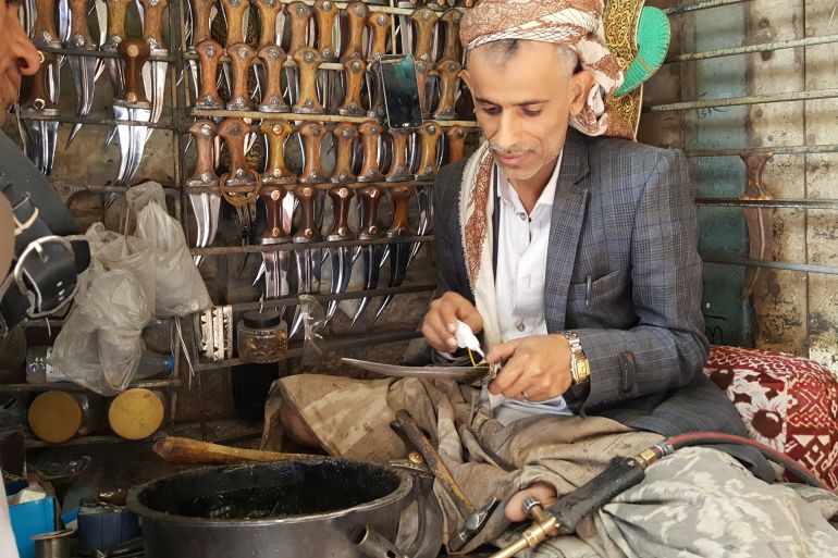 A man in a shop selling traditional Yemeni daggers, jambiyas