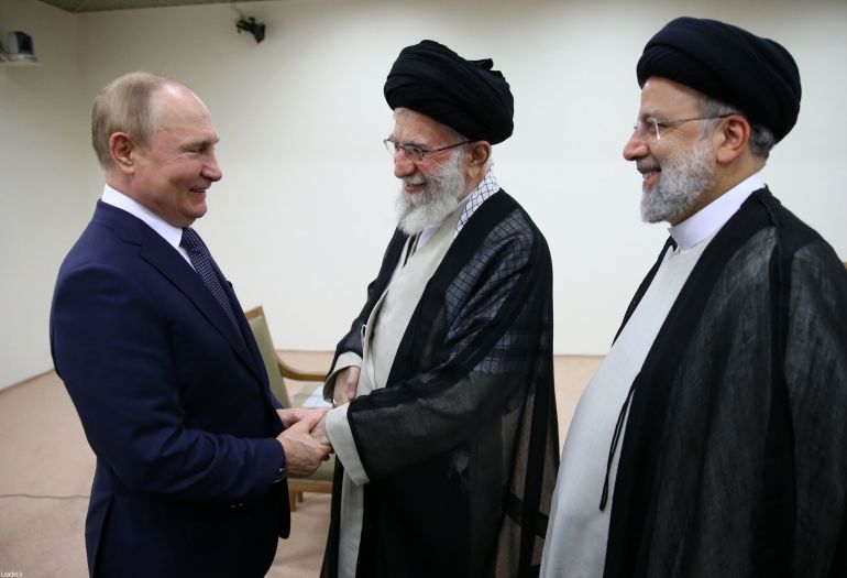Iran's Supreme Leader Ayatollah Ali Khamenei shakes hands with Russia's Vladimir Putin as Iran's President Raisi looks on