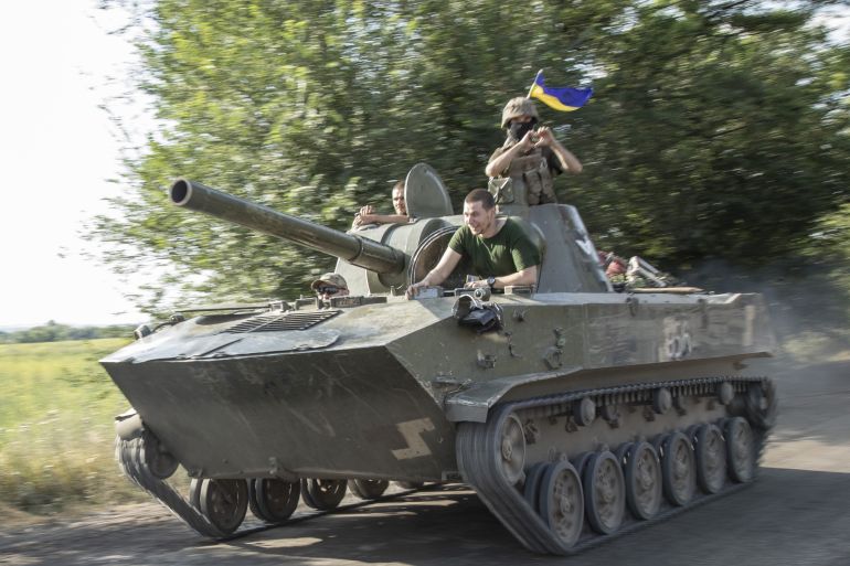 Ukrainian serviceman ride atop a tank towards the battlefield in Siverisk front line, Ukraine