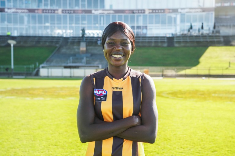 Akec Makur in the yellow and black vertical striped jersey of AFL team Hawthorn.