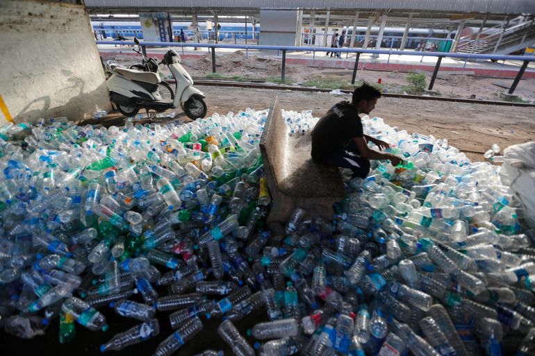 An Indian worker sorts used plastic bottles before sending them to be recycled, at a railway station on World Environment Day in Ahmadabad, India in 2018 [Ajit Solanki/AP]