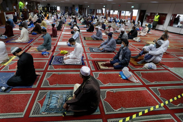 Muslim men are social distanced as they gather to pray at Minhaj-ul-Quran Mosque, at the start of Eid al-Adha, in London