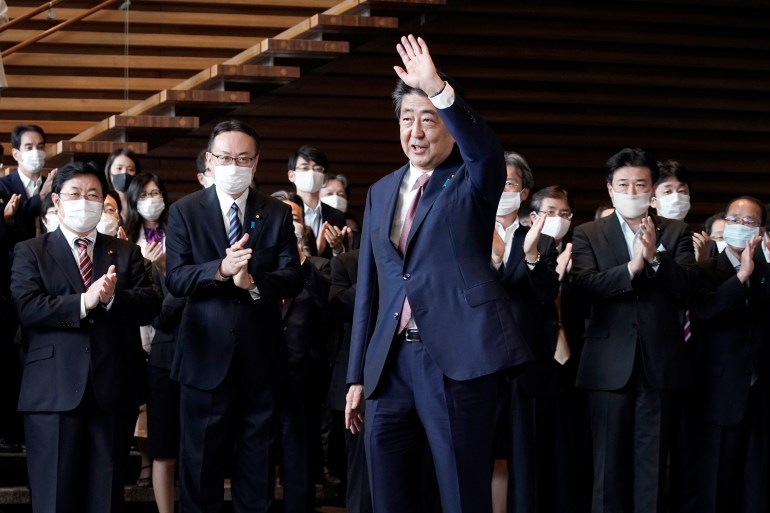 Japan's outgoing Prime Minister Shinzo Abe waves before leaving the prime minister's office Wednesday, Sept. 16, 2020, in Tokyo. Abe and his Cabinet resigned Wednesday, clearing the way for his successor Yoshihide Suga to take over after parliamentary confirmation later in the day. (AP Photo/Eugene Hoshiko)