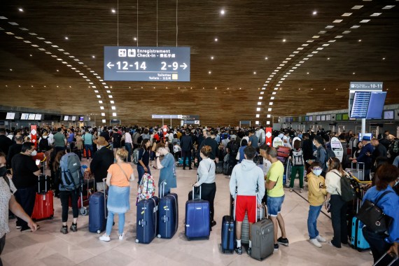 Passengers wait to check in in a terminal of Charles de Gaulle airport
