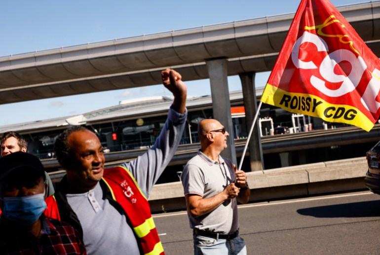 Unionists strikers demonstrate outside a terminal at Roissy airport