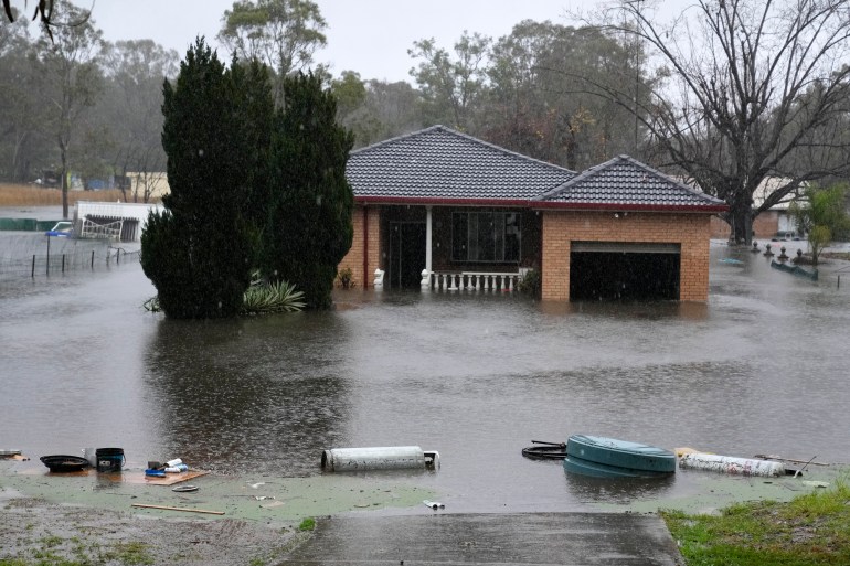 4 Temmuz 2022 Pazartesi, Sidney, Avustralya'nın eteklerinde Richmond yakınlarında bir ev sel sularına yarı batık durumda. 30.000'den fazla Sidney sakinine Pazartesi günü tahliye etmeleri veya evlerini terk etmeye hazırlanmaları söylendi. En büyük şehir, 18 aydaki en kötü sel baskınına hazırlanıyor.  (AP Fotoğrafı/Mark Baker)