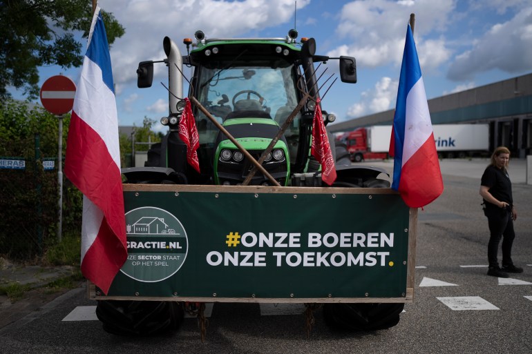 A sign reads "Our Farmers, Our Future" as some 25 tractors put up a blockade outside a distribution center for supermarket chain Albert Heijn in the town of Zaandam