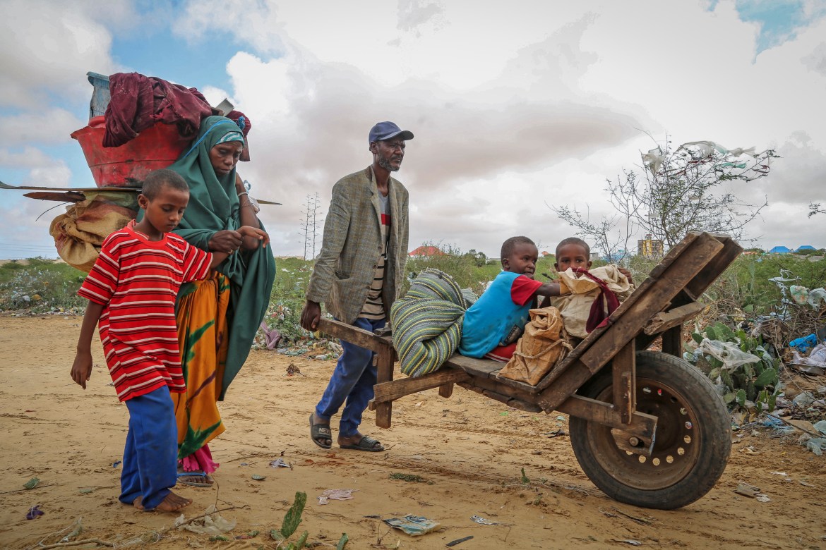 A local resident uses a wheelbarrow to transport the young children of a woman who fled