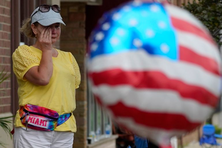 A woman wipes her tears after a mass shooting in Highland Park, Illinois.