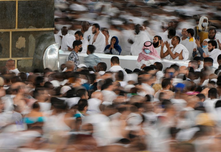 kecepatan rana lambat, jamaah Muslim berdoa sementara yang lain mengelilingi Ka'bah