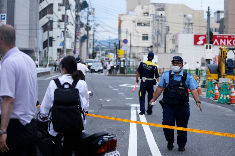 Nara Police officers direct pedestrians and traffic near the scene where the former Prime Minister Shinzo Abe was shot