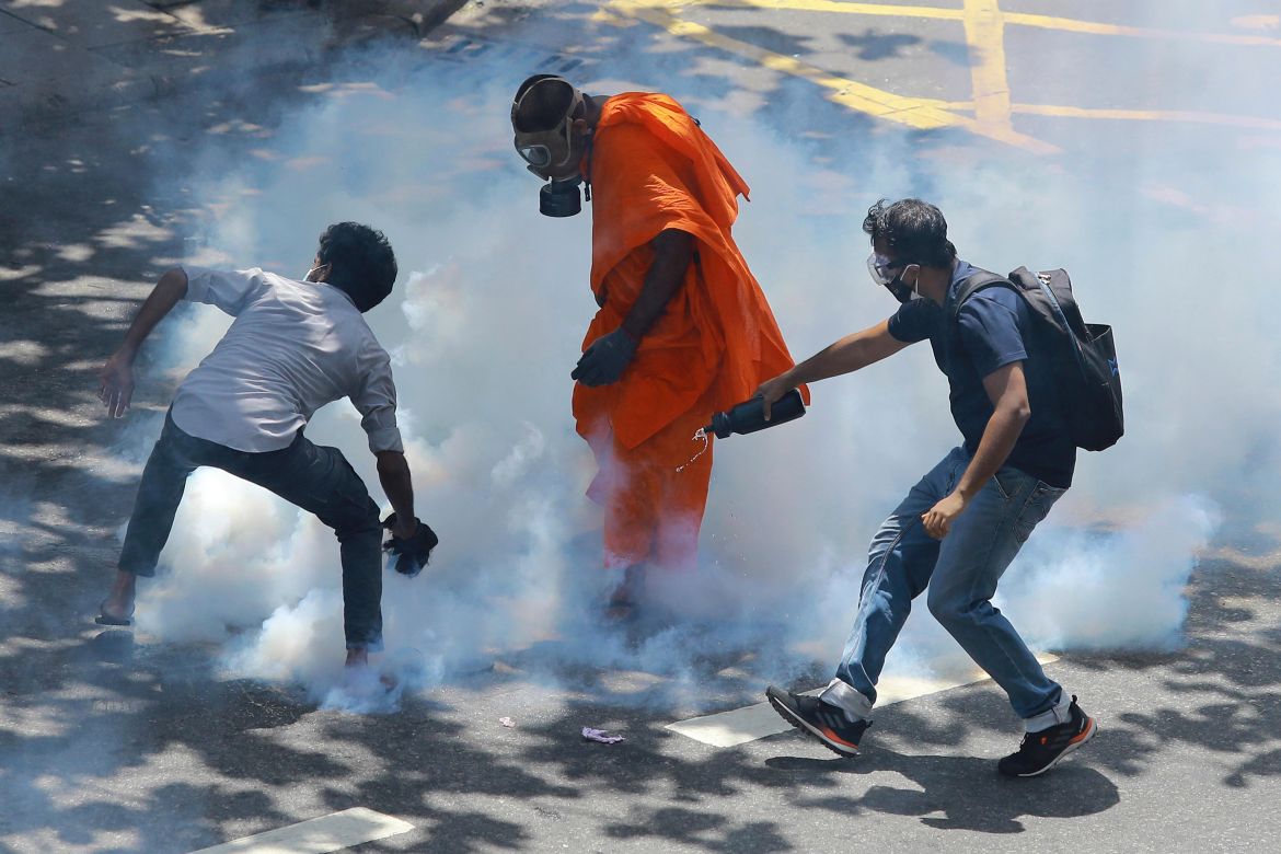 Protesters react after police fired tear gas to disperse them in Colombo
