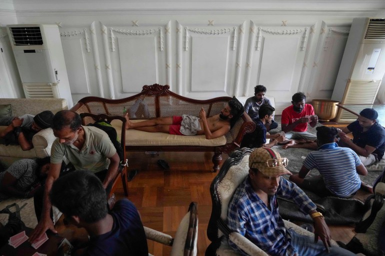 المتظاهرون يبقون ويلعبون الورق في المقر الرسمي لرئيس الوزراء بعد يوم من اقتحامها في كولومبو ، سريلانكا