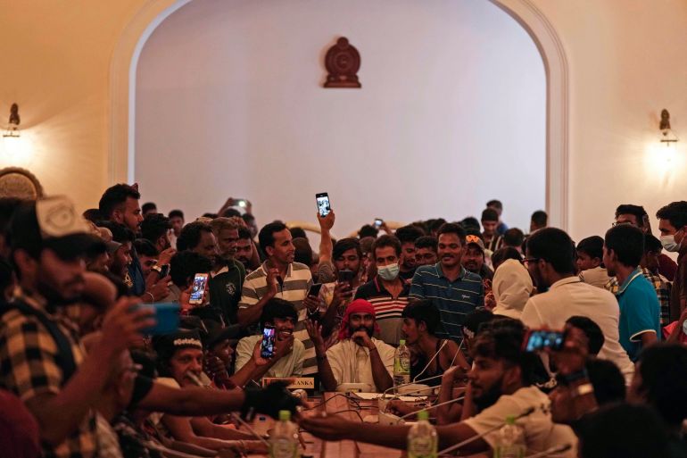 Protesters pretend to hold a cabinet meeting after occupying seats at the cabinet meeting hall of president's official residence a day after it was stormed in Colombo, Sri Lanka