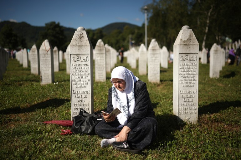 A Bosnian muslim woman prays at a grave in Memorial Centre in Potocari