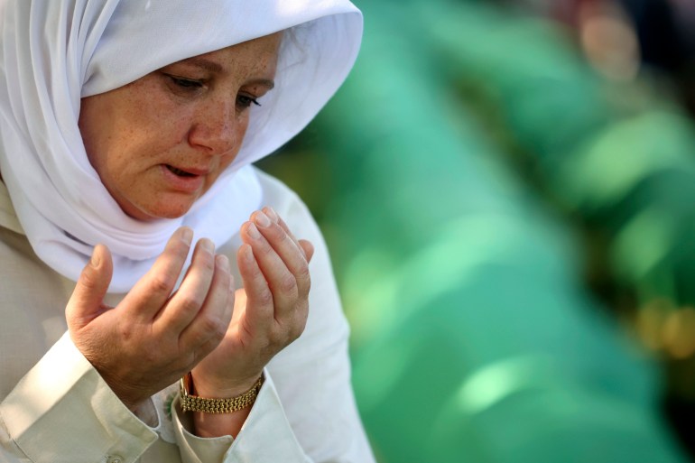 Bosnian muslim woman mourns next to the coffin