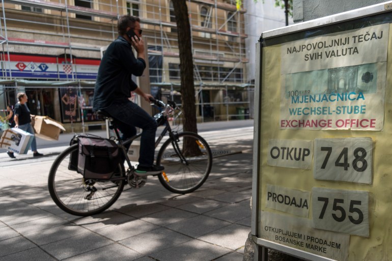 A cyclist rides past an exchange office in downtown Zagreb,