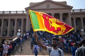 A protester waves a national flag outside the president's office in Colombo, Sri Lanka.