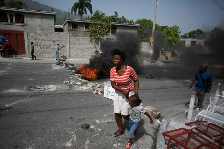 A woman with her son walks past a barricade