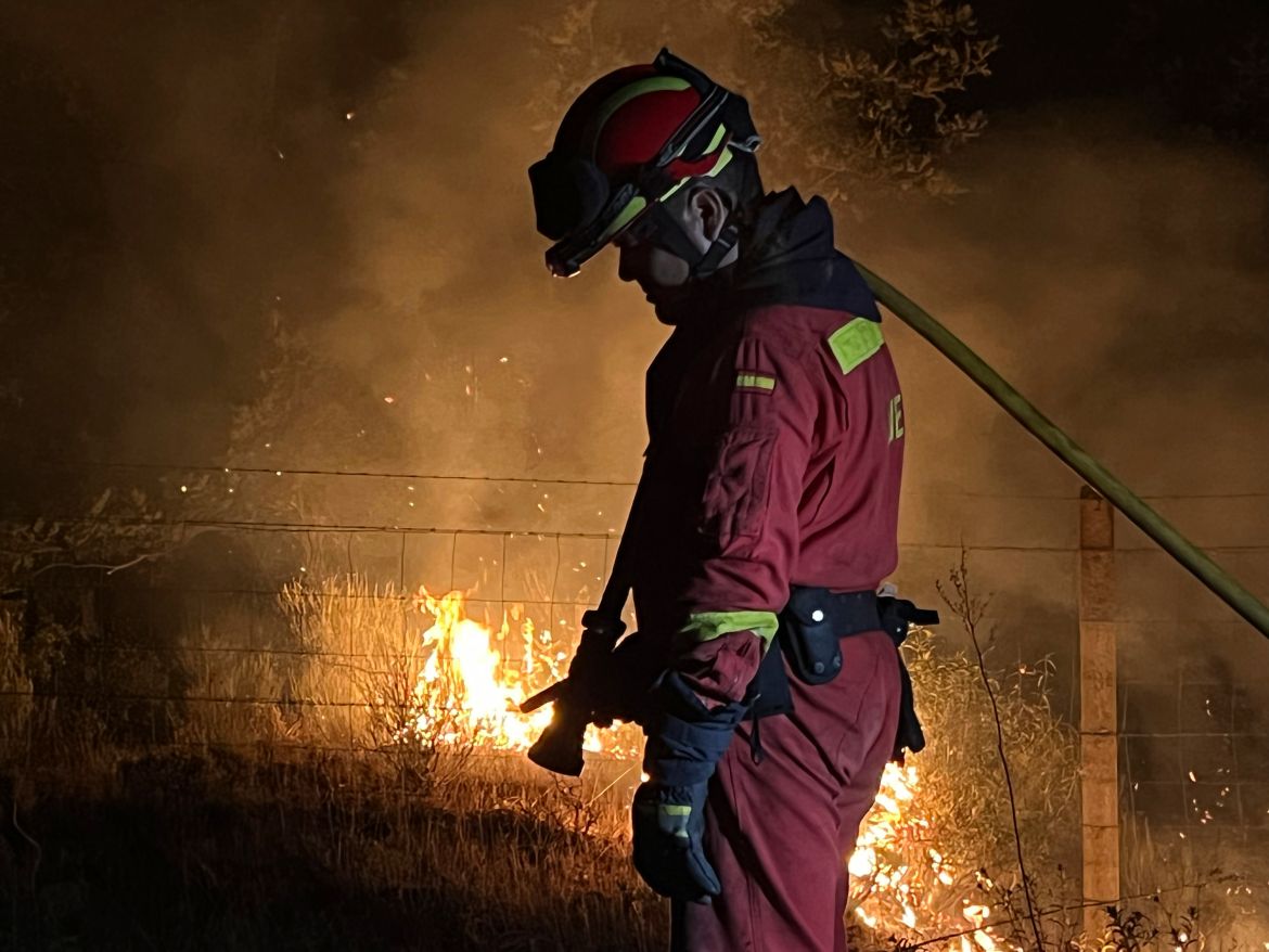 a firefighter works to extinguish a forest fire in the Monsagro area in western Spain
