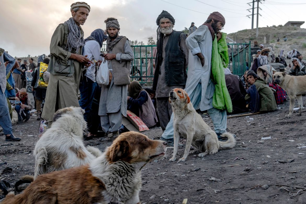 Hundreds of Afghans addicts gather on the edge of a hill to consume drugs