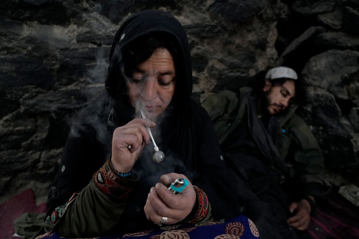 An Afghan drug addict smokes heroin