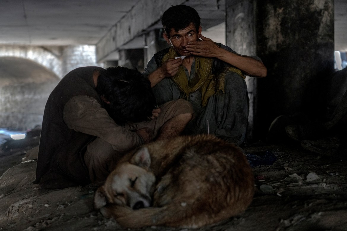 Afghans addicts gather under a bridge to consume drugs