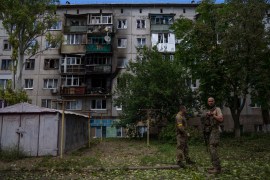 Ukrainian soldiers stand in front of a five-storey building damaged by a rocket attack on a residential area in Kramatorsk, eastern Ukraine [File: Nariman el-Mofty/AP]